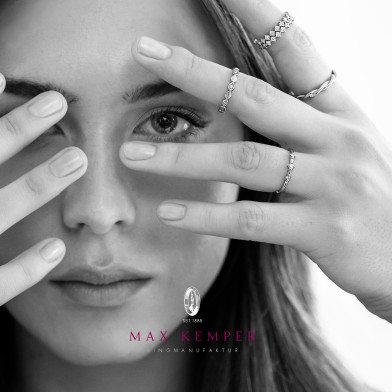 Frau h&auml;lt Hand mit mehreren Ringen vor ihr Gesicht